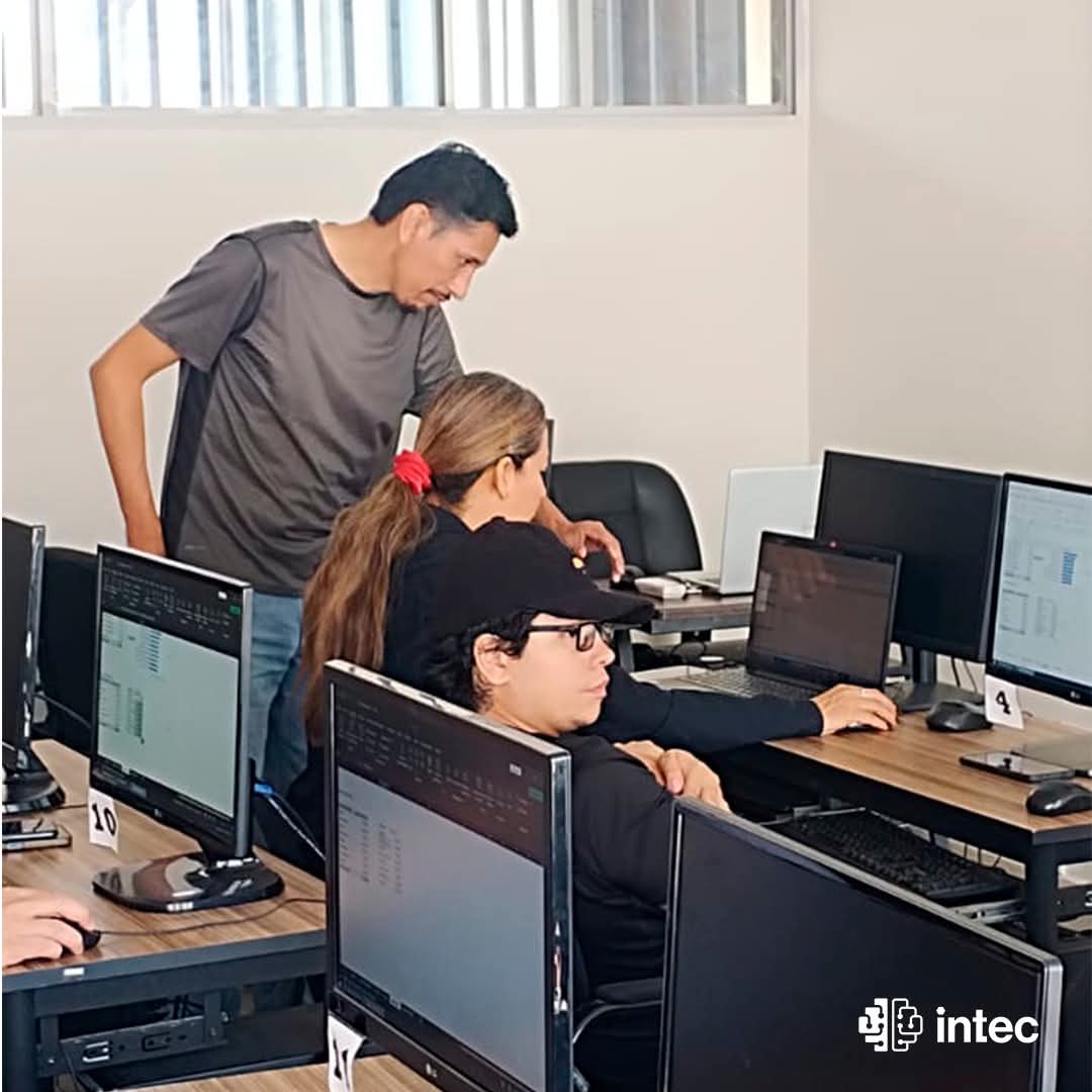 Docente de INTEC acompañando a una estudiante en su computadora